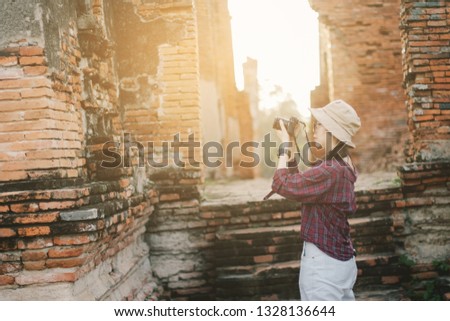 Traveler photographing temples at Historical Park at Ayutthaya., Thailand.