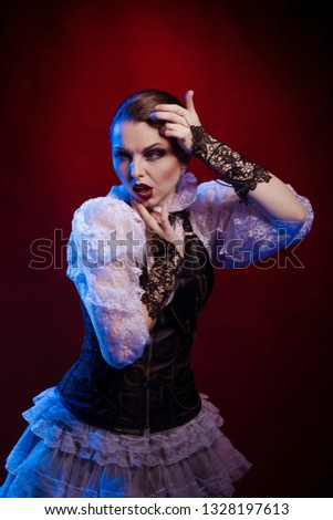 Emotional woman in steampunk costume posing in blue and red stage light