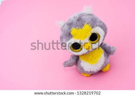 Cute wicked owl toy on pink background