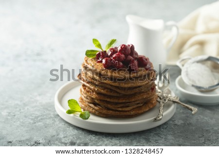Homemade chocolate pancakes with cherry sauce
