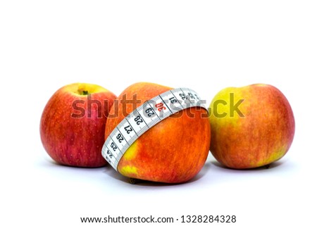 Photo isolated on white background apples and measuring tape. Healthy food for weight loss and keeping fit. Tape for measuring the waist and apples.