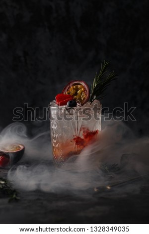 cocktail in a bar on a dark background in smoke and steam. Alcoholic shot with fruit and ice. Food Photography in the studio.