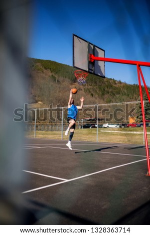Basketball player scoring a slam dunk
