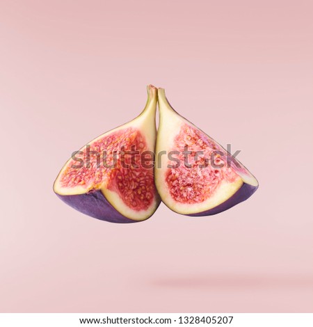 Flying in air fresh ripe  Fig isolated on pastel pink background. High resolution image