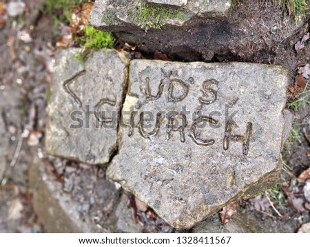 Lud's Church sign on rock at entrance to Lud's Church geological landmark in woods near Gradbach in the Peak District, UK. 