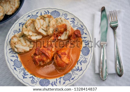 Top view picture of traditional czech dish, chicken with sweet pepper or paprika creamy sauce with bread dumplings served on rustic plate with class of apple cider. Typical for czech or middle europe.