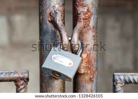 Locked lock old rusty metal door close up. Antique slide steel locked shutter door. The lock, on the grating, closed