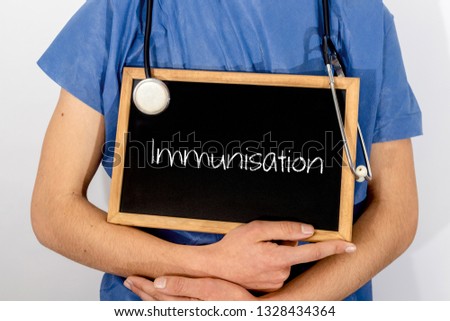 Doctor shows information on blackboard: Immunisation.  Medical concept. Royalty-Free Stock Photo #1328434364