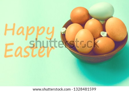 Brown Easter eggs lie in a plate on a blue background. Inscription Happy Easter. Space for text. Easter ideas. Toned image.