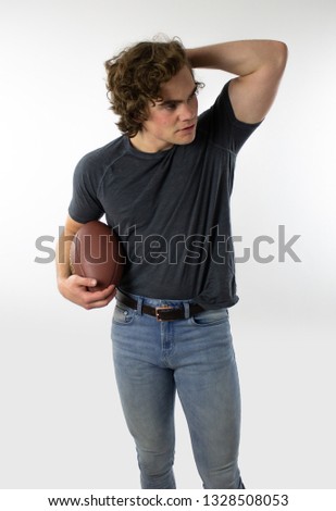 Attractive young man holding football