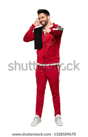 Full-length shot of Handsome sportman making phone gesture and pointing front on isolated white background