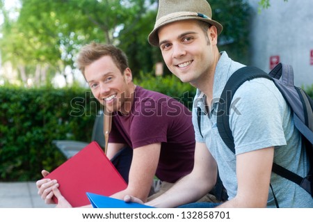 pair of happy young male students on campus