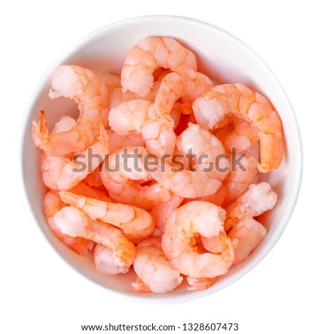 Peeled shrimps in a bowl isolated on white background. Top view