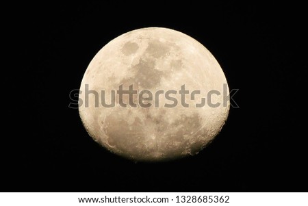 A detailed close up picture of the moon in a black background. Full moon. 