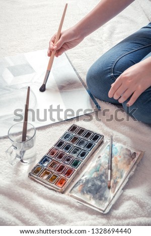 Artist Girl paints on canvas painting on an easel. Hobbies and hobbies relax modern youth generation z, light background