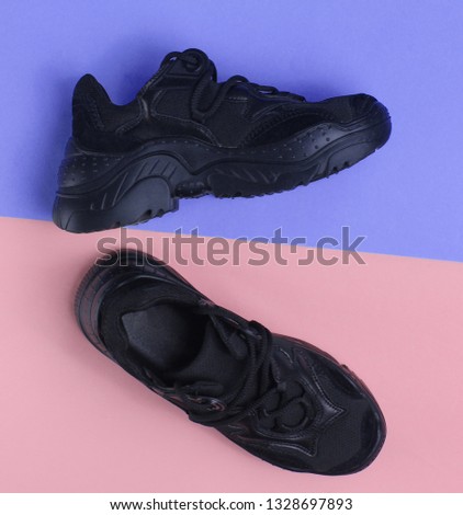 Black sneakers on pastel background. Top view, minimalism
