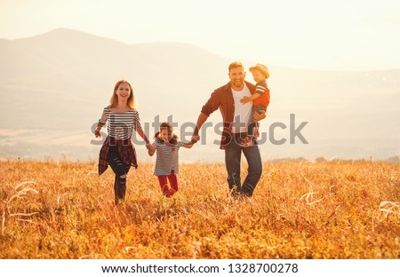 Happy family: mother, father, children son and  daughter on nature  on sunset
