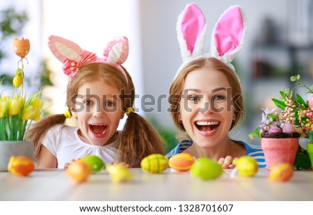 Happy easter! family mother and child daughter with ears hare getting ready for holiday

