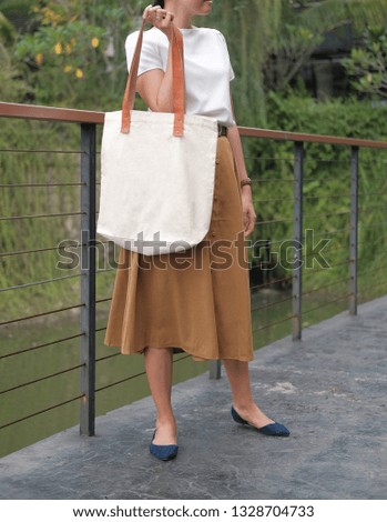 white blank nature canvas tote bag with leather strap mock up in woman hand