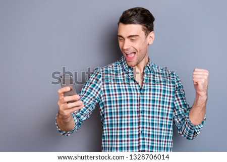 Close up photo attractive amazing he him his man arms hands new telephone smart phone excited with money lottery winning wearing casual plaid checkered shirt outfit isolated grey background