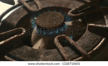 close up detail shot of old rusty kitchen stove ring burning after switched on fire with lighter flame in dangerous gas energy and domestic cooking concept
