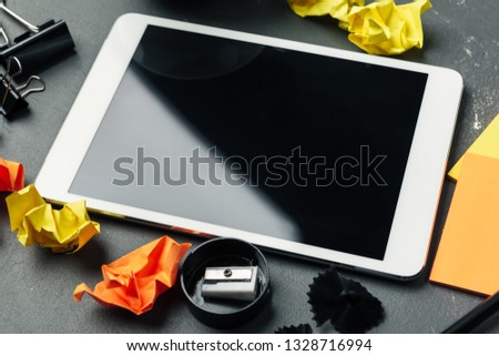 Digital tablet computer and cup of coffee on wooden desk.