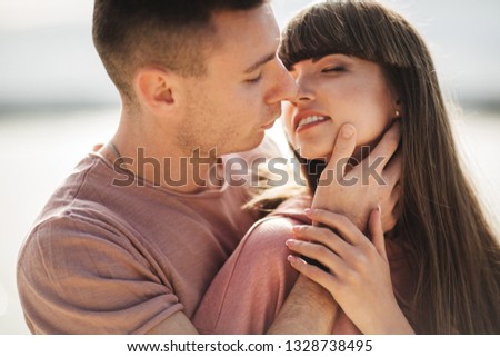 Loving young couple kissing and hugging in outdoors. Love and tenderness, dating, romance, family, anniversary concept.