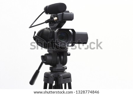 The side view of the video camera with the tripod isolated on white background.