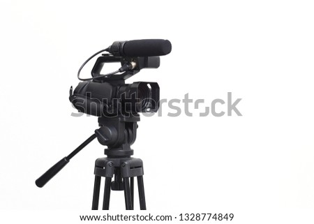 The side view of the video camera with the tripod isolated on white background.