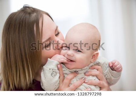 Young mother kisses her son