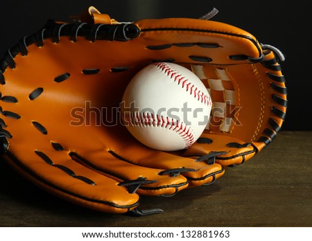Baseball glove and ball on dark background