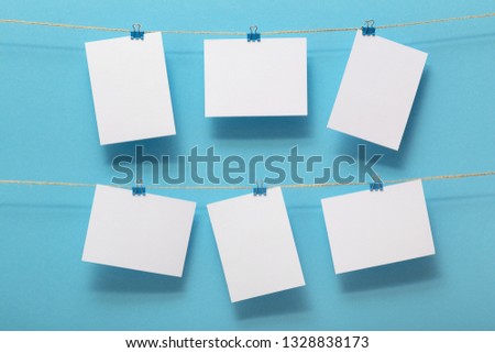 place for photo cards, empty blanks attached to a linen rope in two rows with clips on a colored background, a concept template for text, images, idea for home decor