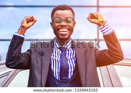happy lucky and successful afro american businessman proud of himself and buying a cool car. concept of a good deal and victory