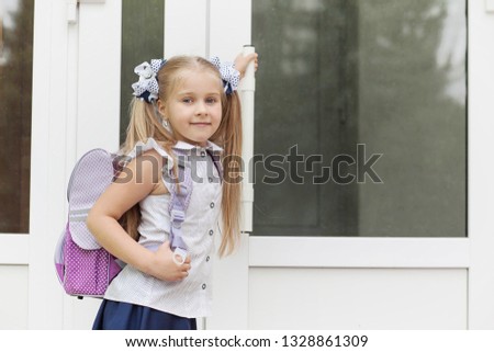 Back to school and happy time! Cute industrious blond child girl outdoors. Schoolgirl in school uniform. 