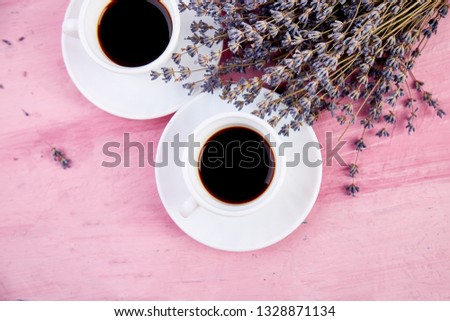 Two cups of coffee  with bouquet of flowers lavender on pink table. Good morning, beautiful breakfast, greeting card, top view, flat lay. Copy space.