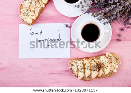Two cups of coffee  with bouquet of flowers lavender  and healthy toasts breakfast  and notes good morning on pink table, beautiful breakfast, greeting card, top view, flat lay. Copy space.