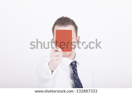 Portrait of a businessman holding up a red card as a symbol for negative expression. Studio shot on a white background.