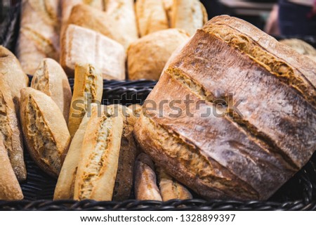 Homemade breads cooked in wood-fired oven as formerly yummy. Delicious large breads packed with flour in a basket