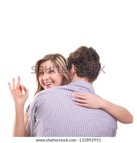 young smiling beautiful blond girl showing ok sign from her boyfriend's back