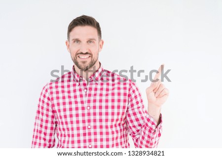 Young handsome man wearing shirt over isolated background with a big smile on face, pointing with hand and finger to the side looking at the camera.