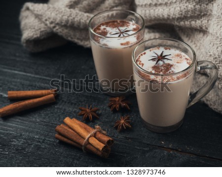 Homemade tea latte with cinnamon stick on wooden rustic background