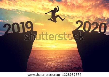 Businessman jump between 2019 and 2020 years. Royalty-Free Stock Photo #1328989379