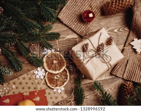 gift box dry orange slices snowflakes package warm clothes branch of green festive tree Christmas New Year