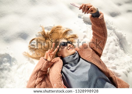 Happy woman taking selfie on winter day