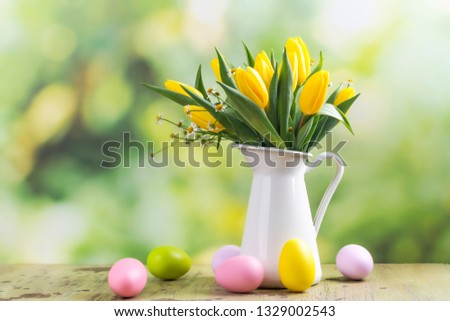 Easter greeting card with bunch of tulips and easter eggs in a summer garden. Copy space