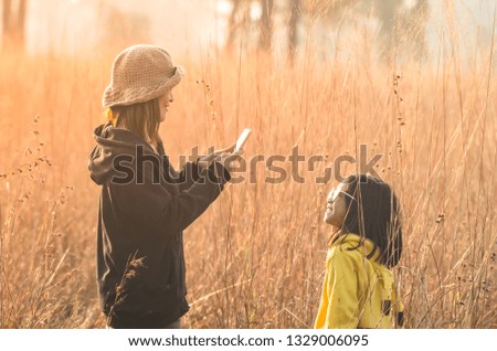 On holidays in the grasslands and with mild sunlight Mother and daughter and enjoy shooting