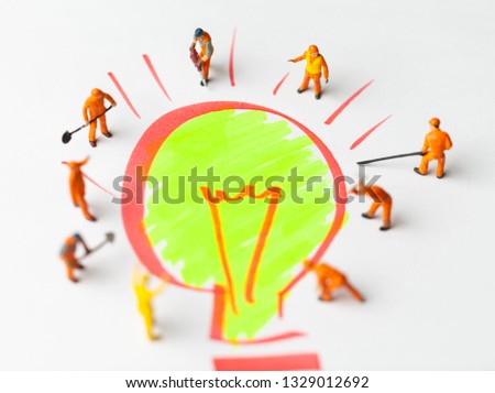 Miniature people on paper with light bulb. The concept of a collective solution to any problem.