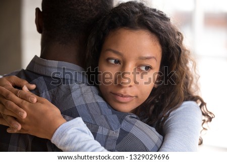 Pensive young mixed race girlfriend think of something hugging boyfriend making peace after fight, worried black woman doubt in relationships, embracing with beloved. Couple distrust, cheating concept Royalty-Free Stock Photo #1329029696