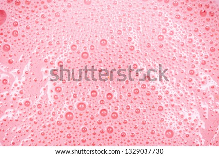 Strawberry milkshake texture. Pink bubbles of berry drink froth.Extreme close-up macro. Above view. Royalty-Free Stock Photo #1329037730