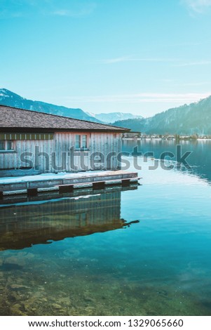 Wooden fishing house on the coast of the lake Tegernsee. Alpine mountains in Bavaria (Bayern). Mountain view, beautiful landscape in Germany. Adventure in Europe (travel photo). 